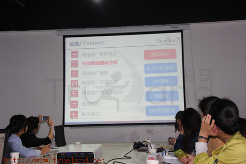 拿出手機和相機拍攝演示PPT內容的學員